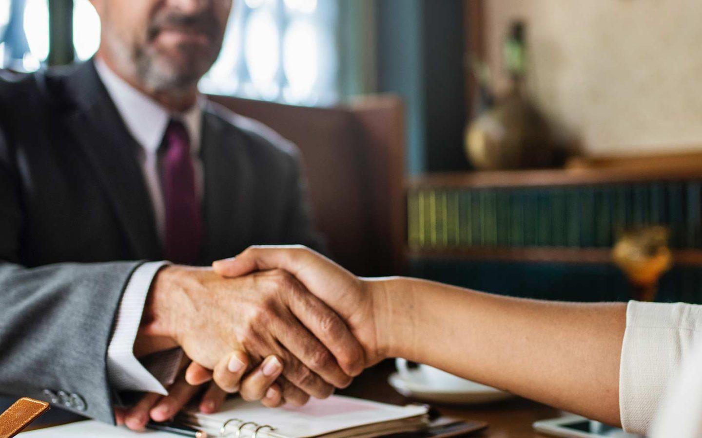 close up photo of a business man and woman's hands shaking