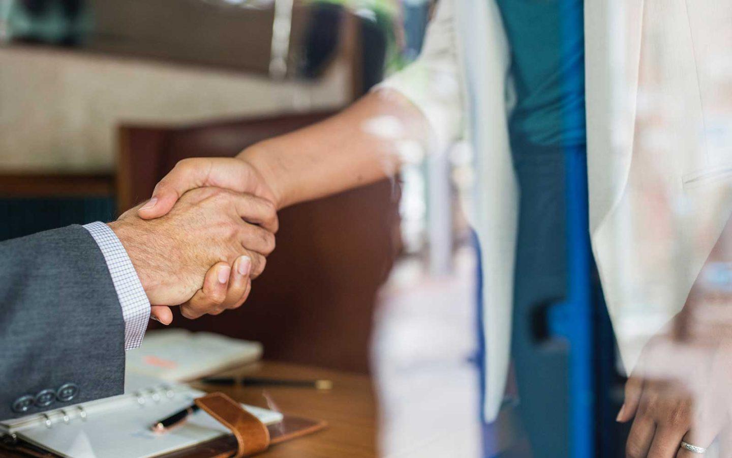 close up photo of a business man and woman's hands shaking