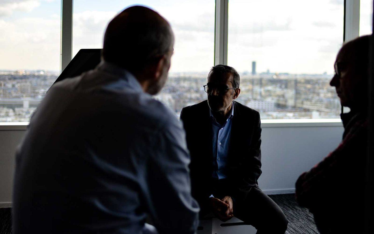 three people sitting in conversation in an office